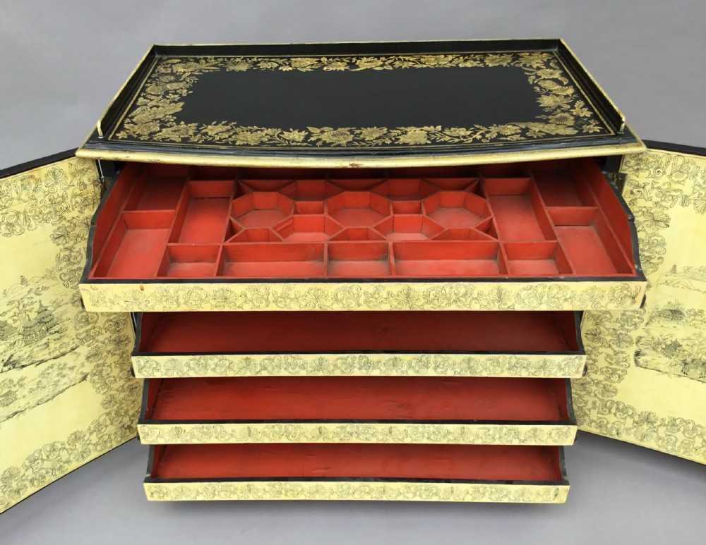 A Regency black lacquered collectors cabinet on stand featuring detailed cream and gilt Chinoiserie penwork illustrations of oriental figures and floral borders. View XVII