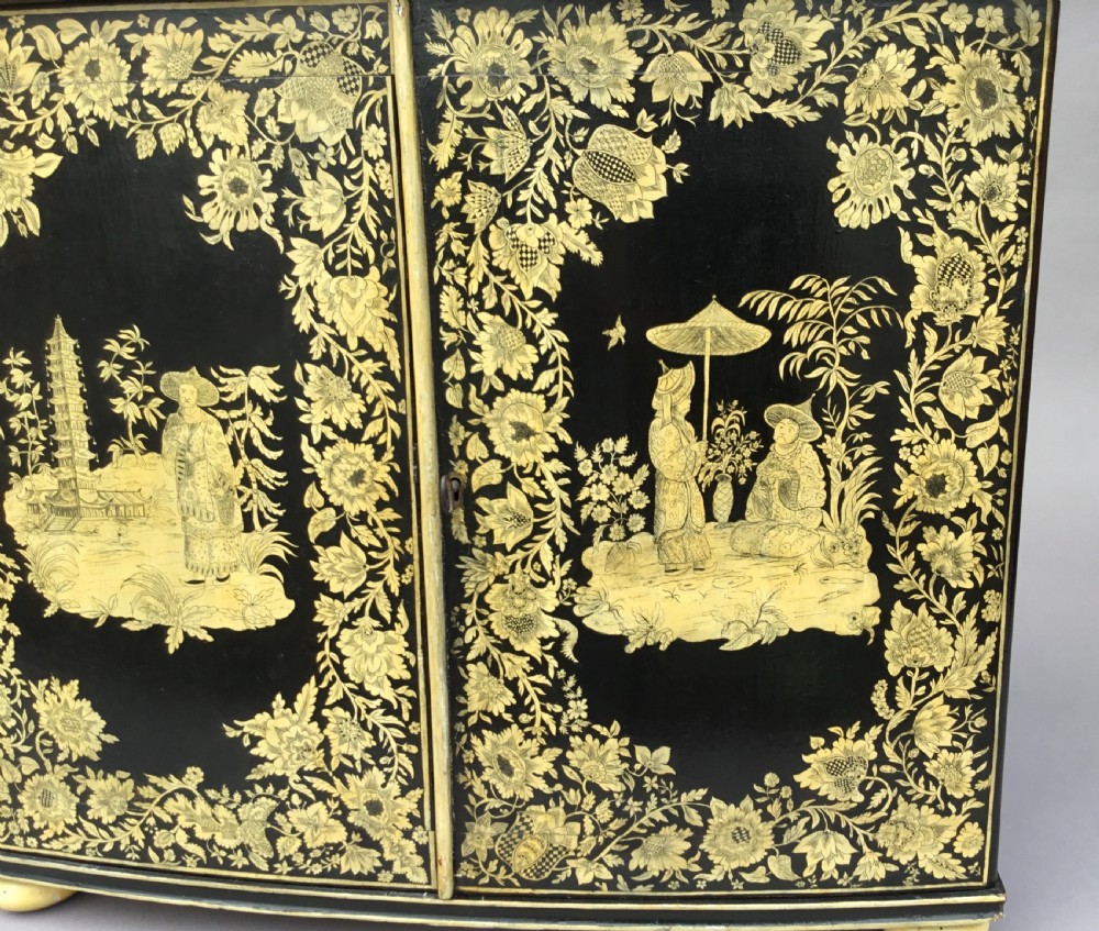 A Regency black lacquered collectors cabinet on stand featuring detailed cream and gilt Chinoiserie penwork illustrations of oriental figures and floral borders. View XXI