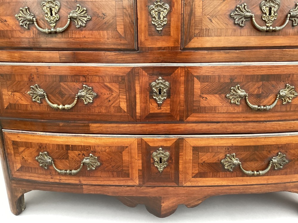 An 18th-century Louis XV bow-fronted kingwood commode featuring geometric parquetry drawers, cast bronze handles, keyhole escutcheons, and a thick marble top. View III