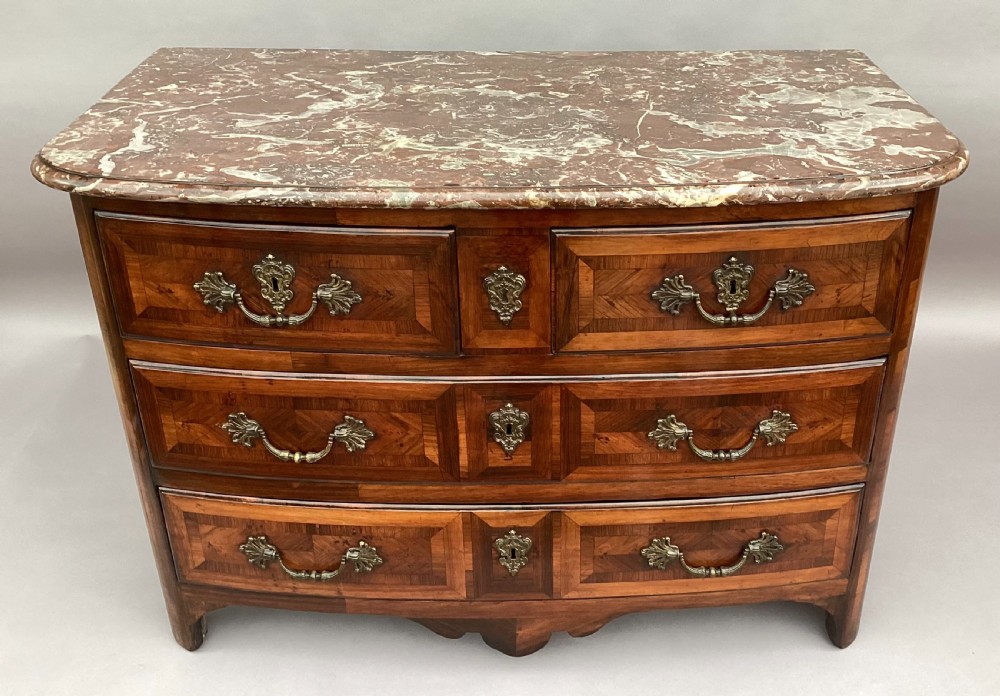 An 18th-century Louis XV bow-fronted kingwood commode featuring geometric parquetry drawers, cast bronze handles, keyhole escutcheons, and a thick marble top. View VI