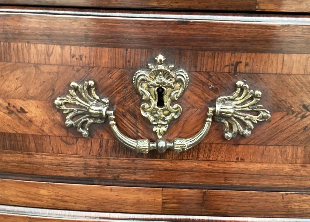 An 18th-century Louis XV bow-fronted kingwood commode featuring geometric parquetry drawers, cast bronze handles, keyhole escutcheons, and a thick marble top. View VII