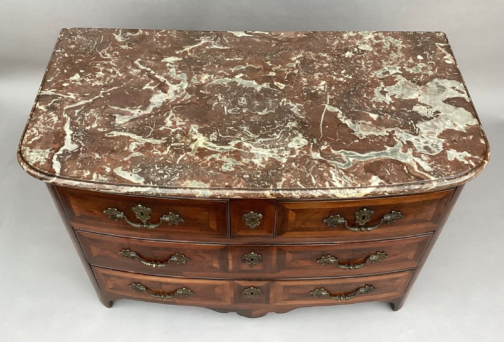 An 18th-century Louis XV bow-fronted kingwood commode featuring geometric parquetry drawers, cast bronze handles, keyhole escutcheons, and a thick marble top. View VIII