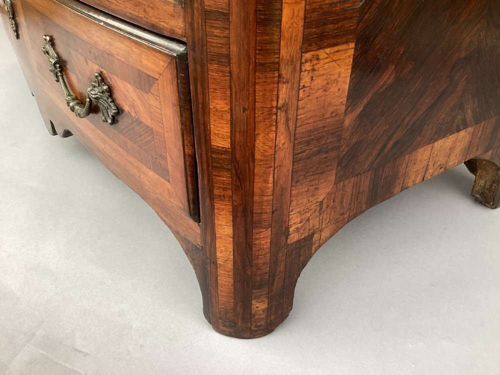 An 18th-century Louis XV bow-fronted kingwood commode featuring geometric parquetry drawers, cast bronze handles, keyhole escutcheons, and a thick marble top. View IX