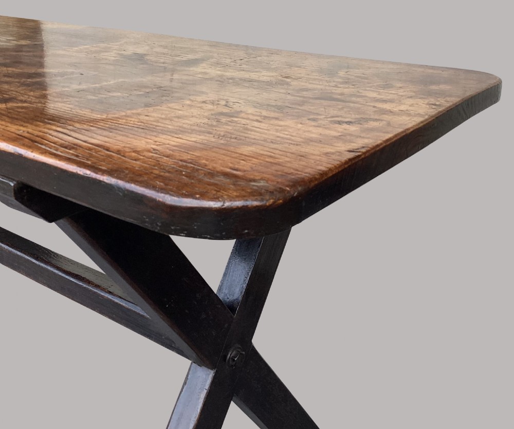 A Georgian elm tavern table featuring a long rectangular polished timber top over a dark X-frame base. View XII