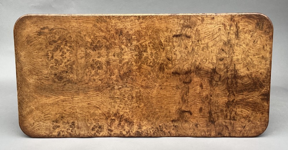 A mid-19th-century centre table crafted from figured burr and pollard oak, featuring rounded corners, a central carved medallion on the frieze, and twin end-standard supports on sledge bases. View XI