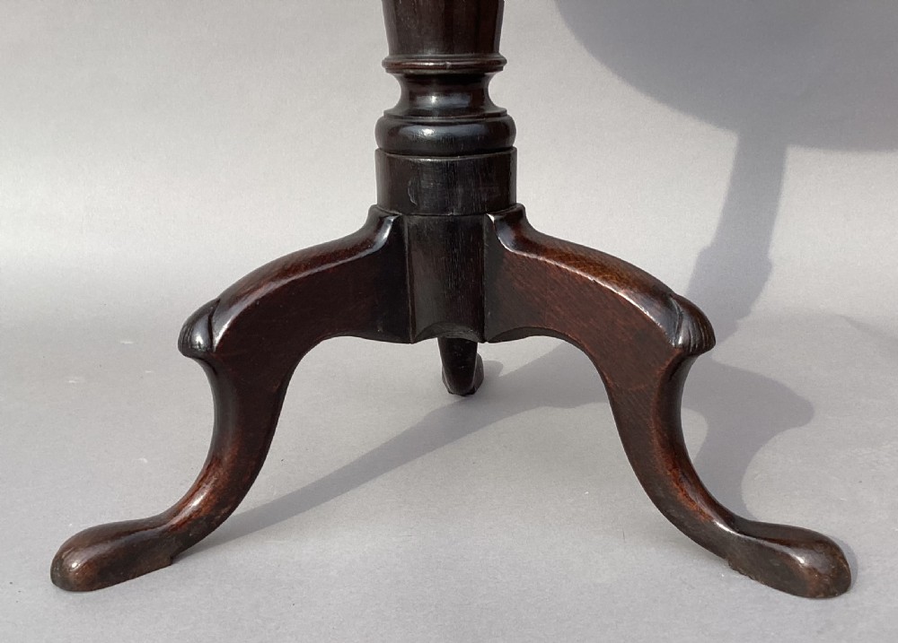 An 18th-century Irish Georgian burr oak tripod wine table featuring a circular top, turned central pedestal, and three cabriole legs terminating in pad feet. View VII
