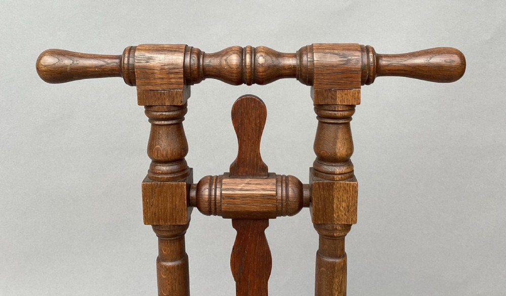 A George IV standing oak boot jack featuring turned upright columns, a crossbar handle, and a flat notched base. View XII
