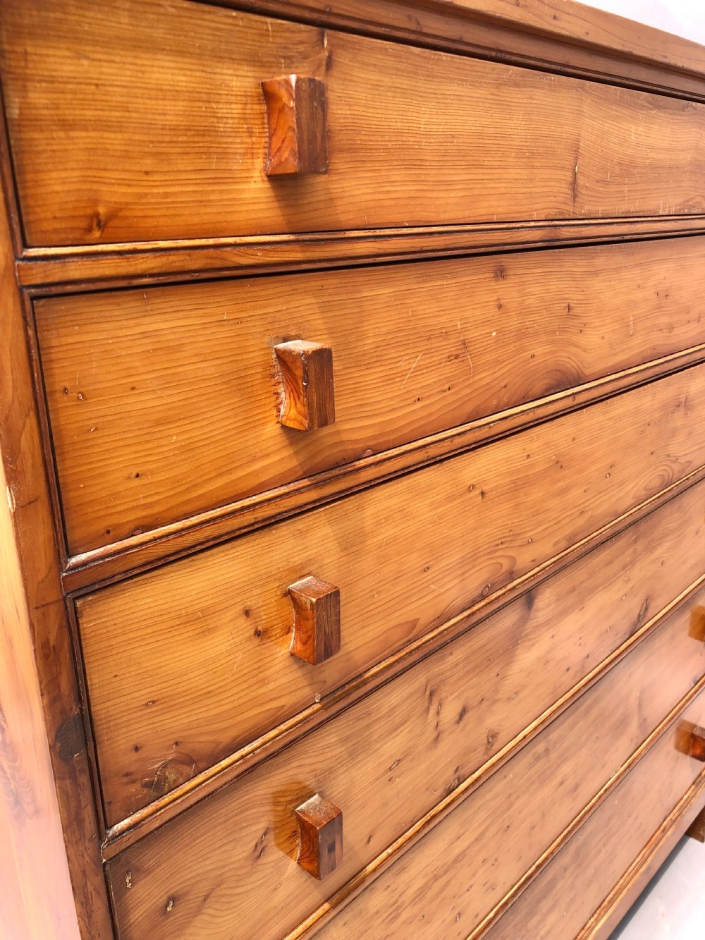 An Arts and Crafts solid yew wood chest featuring six graduated drawers with simple square wooden pulls. View XII
