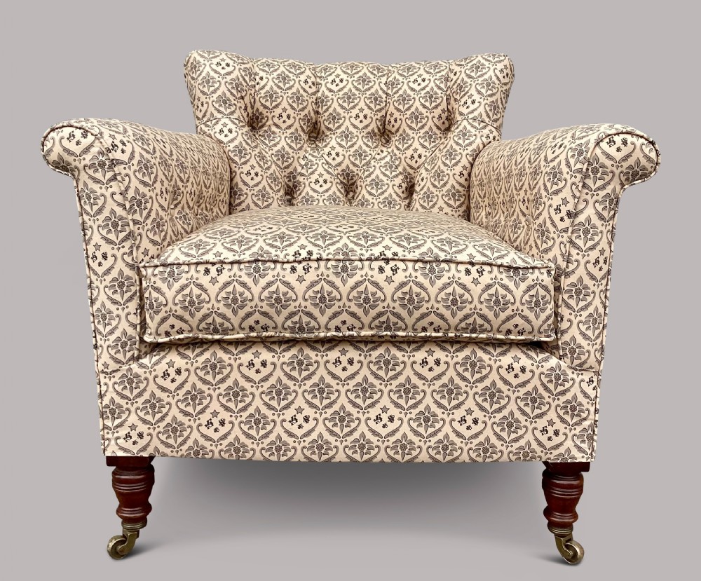 A Victorian Howard and Sons Woodstock armchair upholstered in patterned cream fabric with turned timber legs and brass castors. View VII