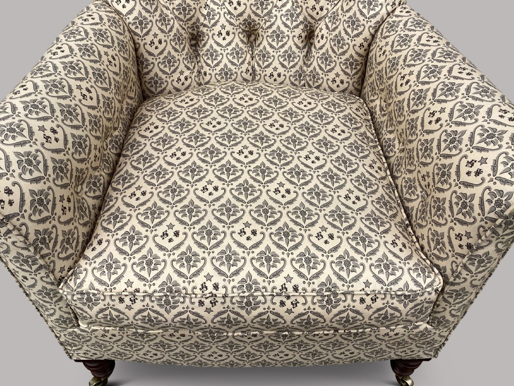 A Victorian Howard and Sons Woodstock armchair upholstered in patterned cream fabric with turned timber legs and brass castors. View XI