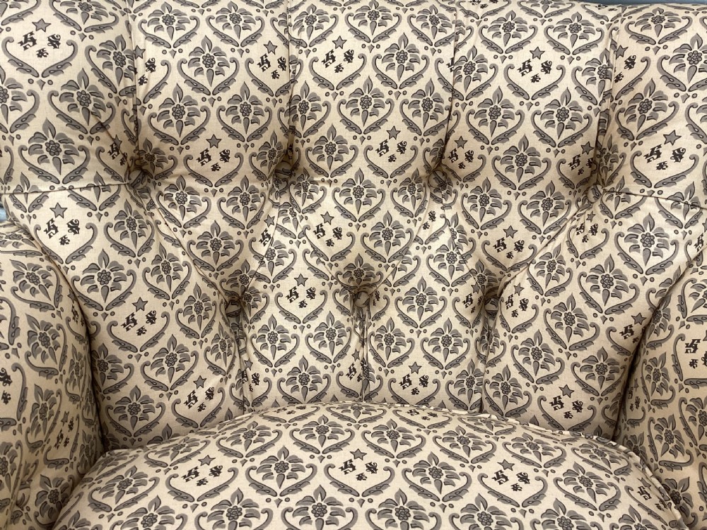 A Victorian Howard and Sons Woodstock armchair upholstered in patterned cream fabric with turned timber legs and brass castors. View XII
