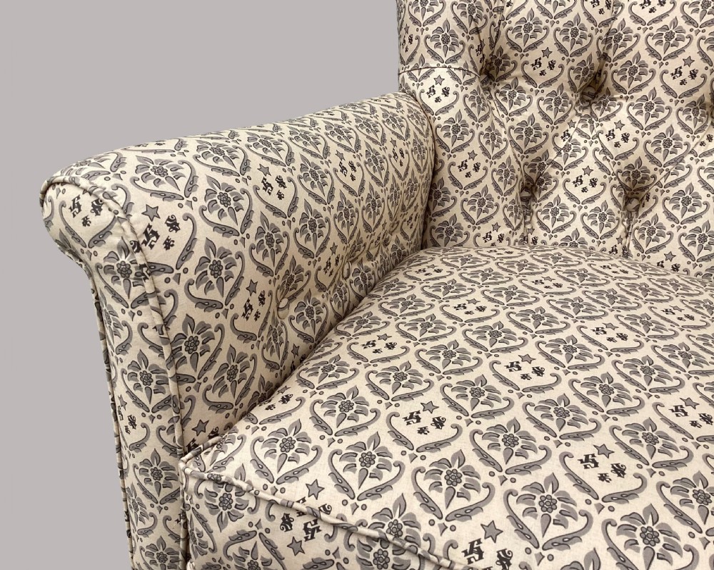 A Victorian Howard and Sons Woodstock armchair upholstered in patterned cream fabric with turned timber legs and brass castors. View XIV