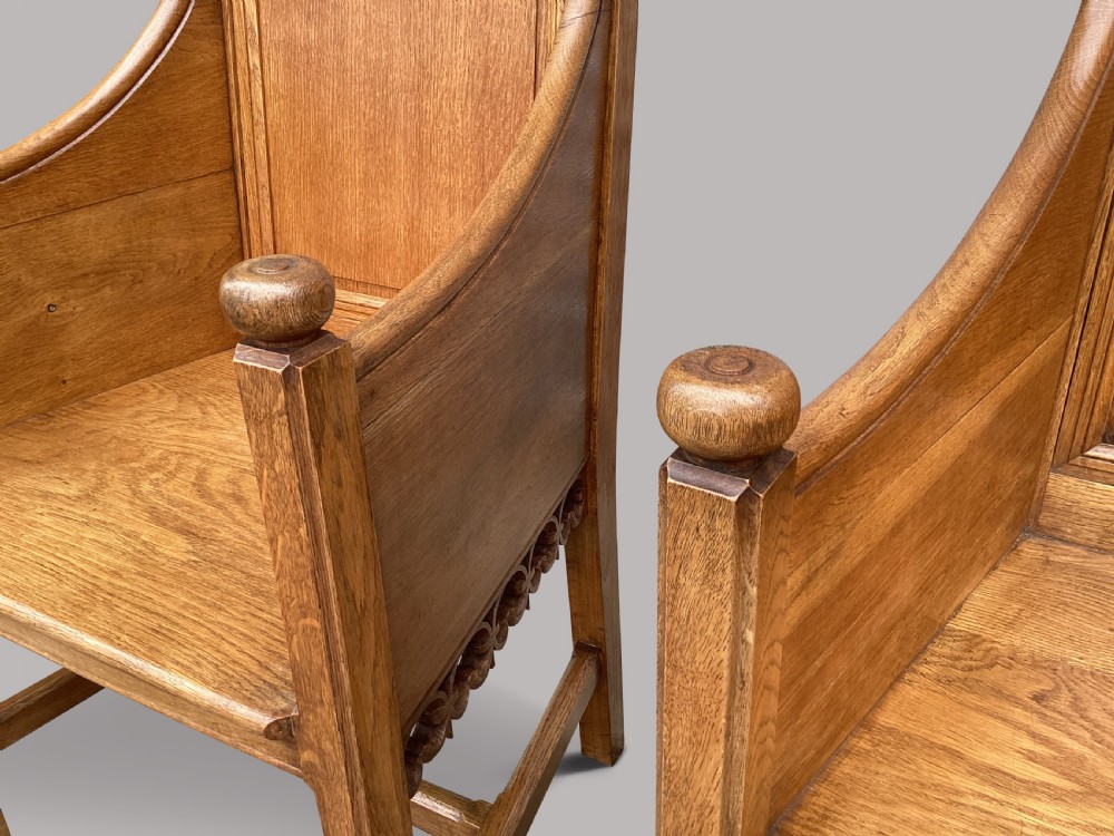 A pair of 19th-century golden oak Gothic Revival armchairs featuring high panelled backrests, shaped arms with spherical terminals, and solid oak seats. View V