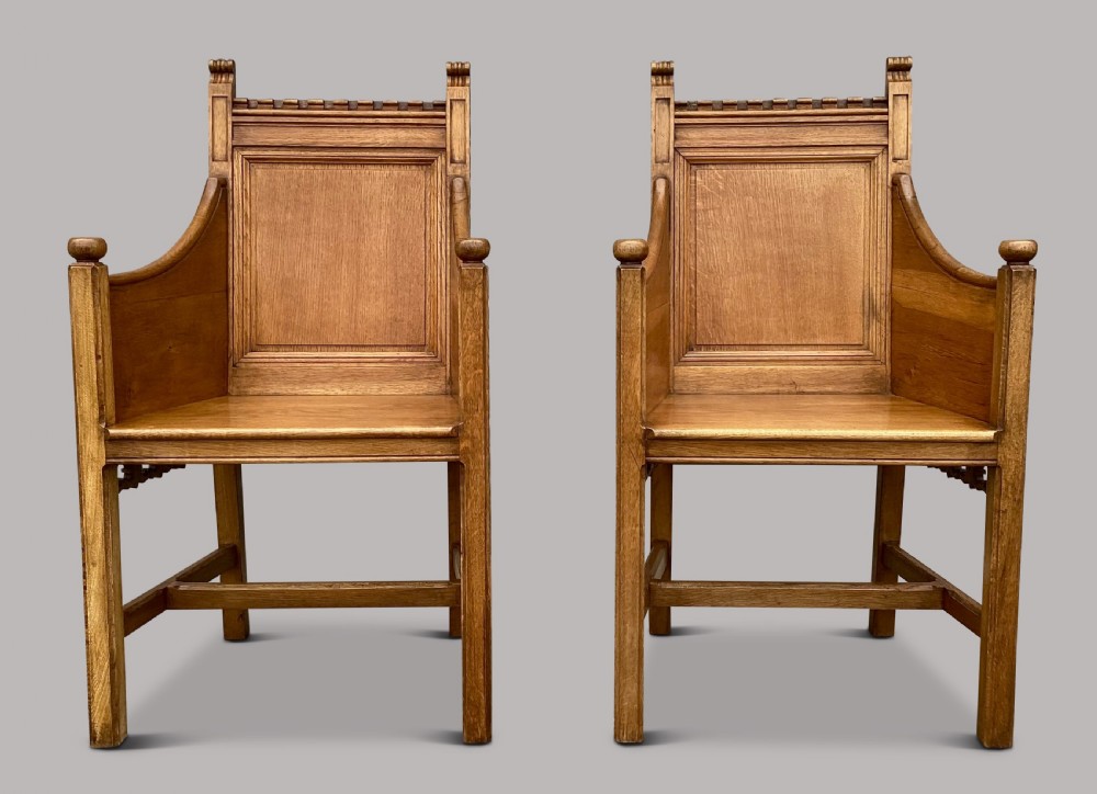 A pair of 19th-century golden oak Gothic Revival armchairs featuring high panelled backrests, shaped arms with spherical terminals, and solid oak seats. View VIII