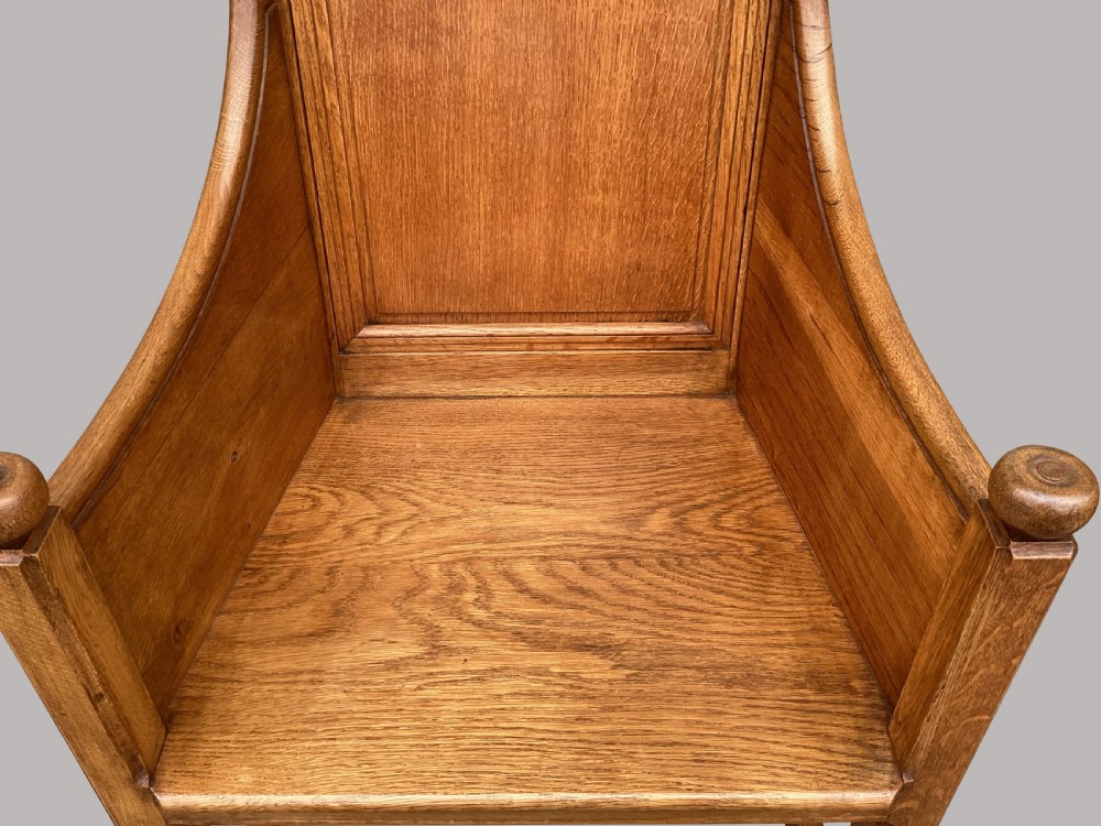 A pair of 19th-century golden oak Gothic Revival armchairs featuring high panelled backrests, shaped arms with spherical terminals, and solid oak seats. View XI