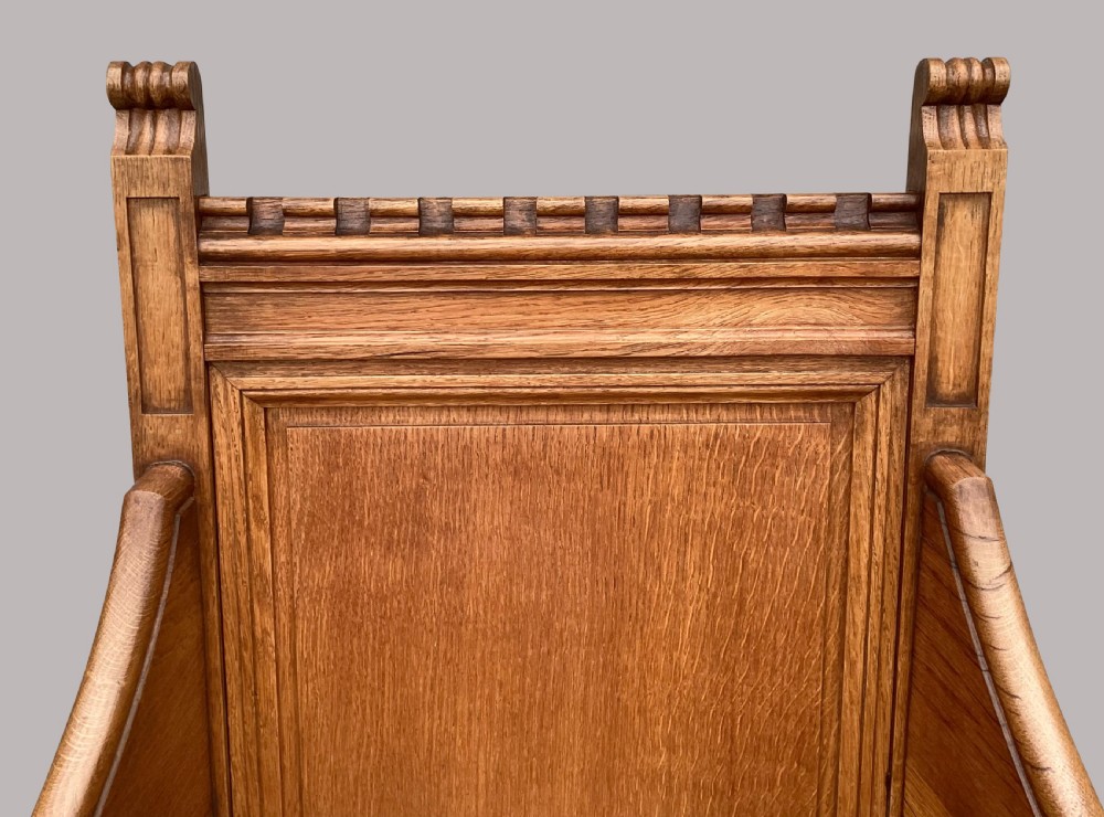 A pair of 19th-century golden oak Gothic Revival armchairs featuring high panelled backrests, shaped arms with spherical terminals, and solid oak seats. View XV