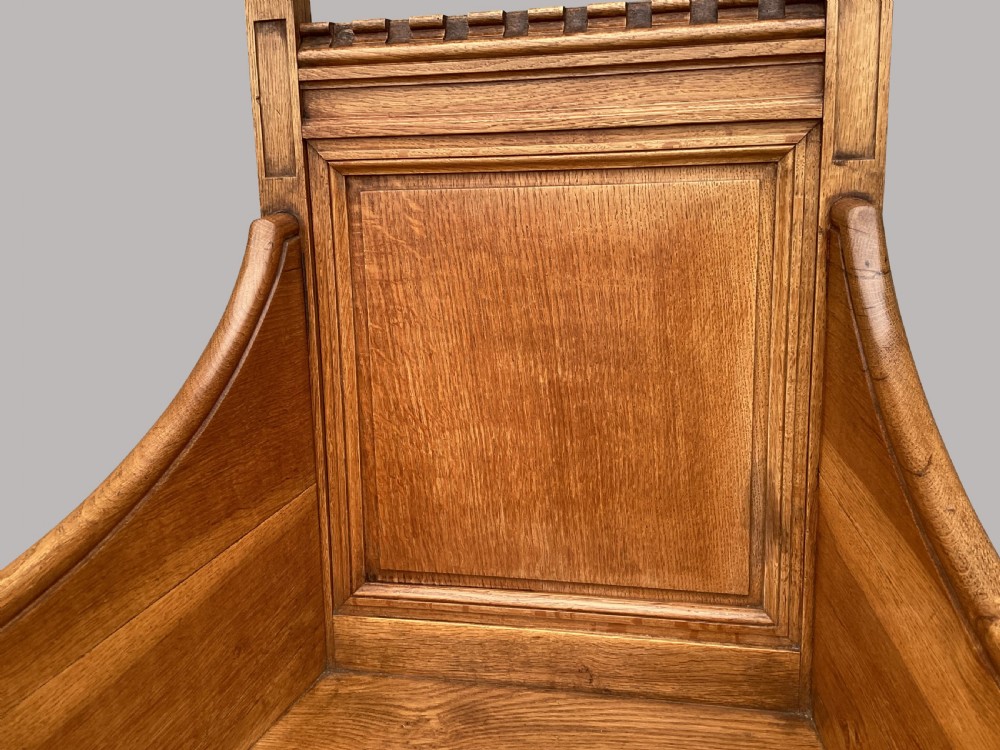 A pair of 19th-century golden oak Gothic Revival armchairs featuring high panelled backrests, shaped arms with spherical terminals, and solid oak seats. View XVI