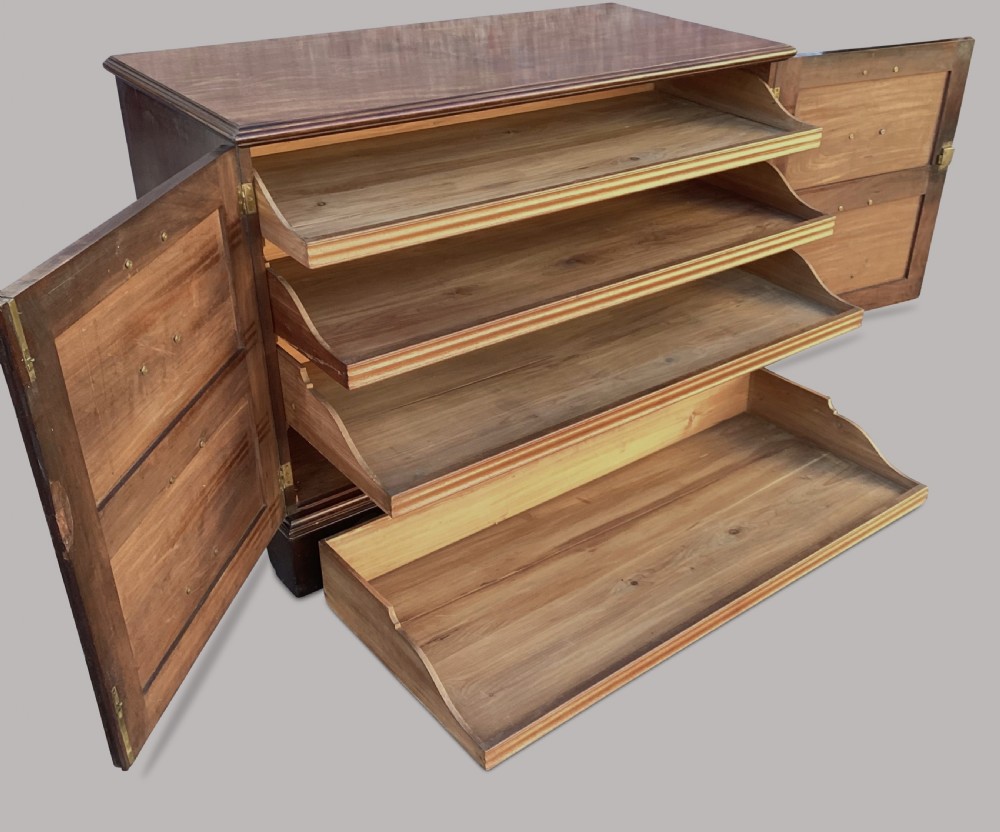 A George III mahogany low press cupboard with doors styled as faux drawers, brass swan-neck handles, bracket feet, and internal sliding shelves. View VII