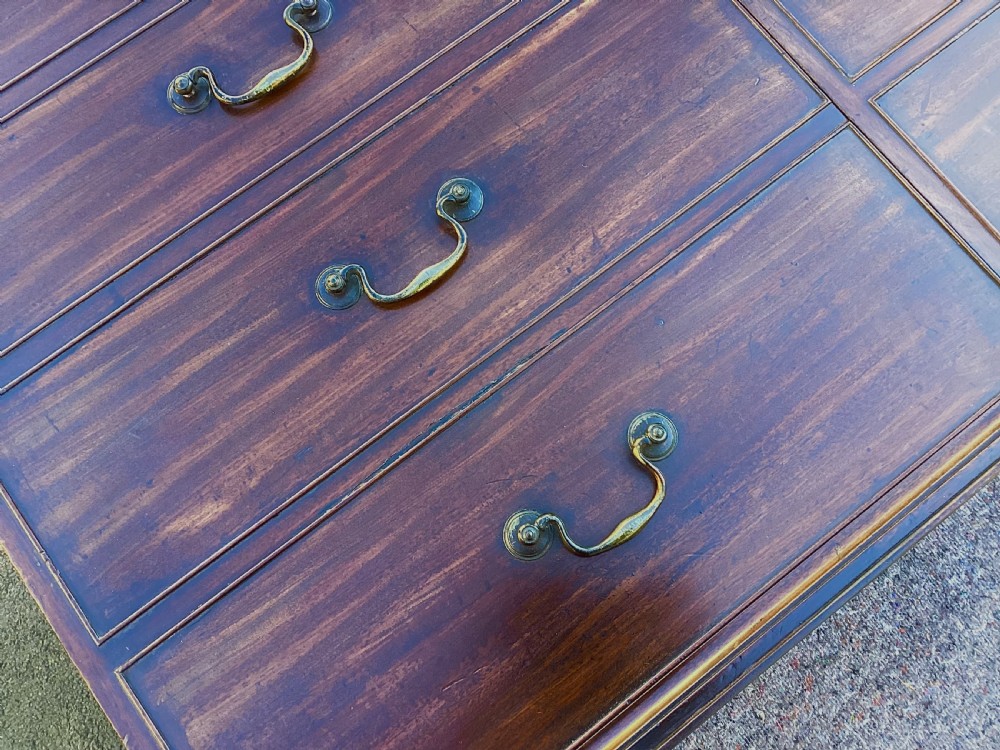 A George III mahogany low press cupboard with doors styled as faux drawers, brass swan-neck handles, bracket feet, and internal sliding shelves. View XI