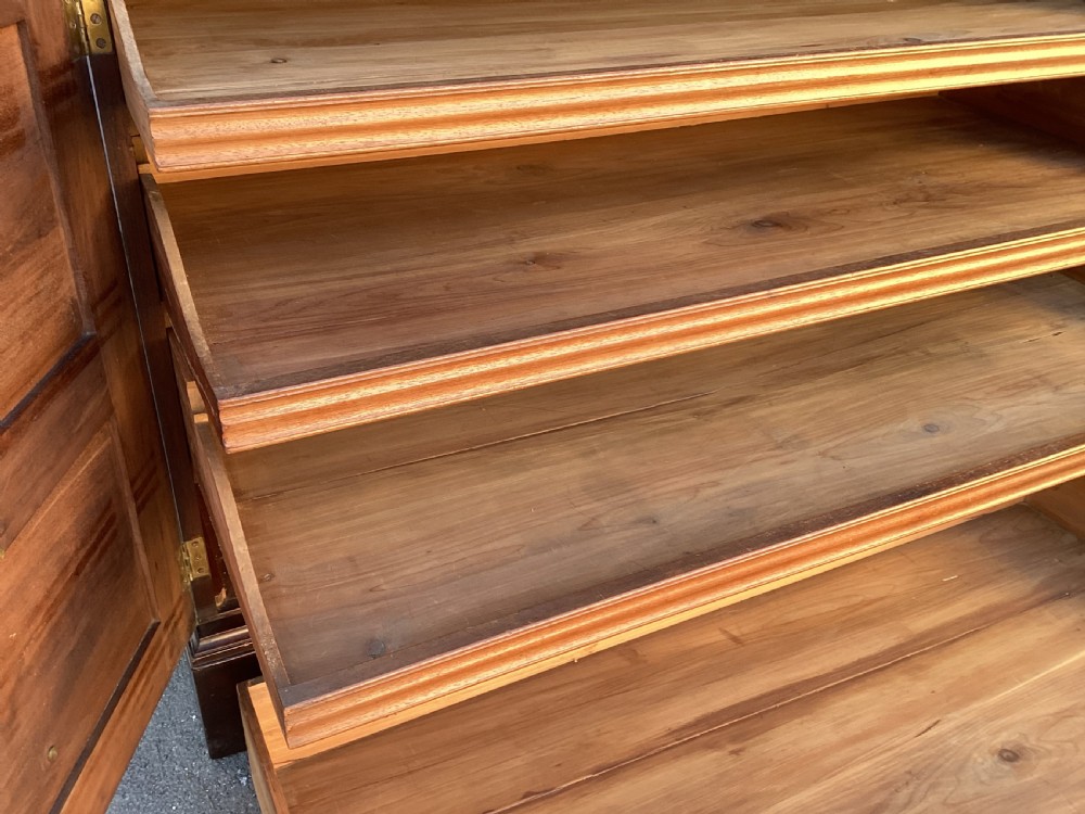A George III mahogany low press cupboard with doors styled as faux drawers, brass swan-neck handles, bracket feet, and internal sliding shelves. View XVI