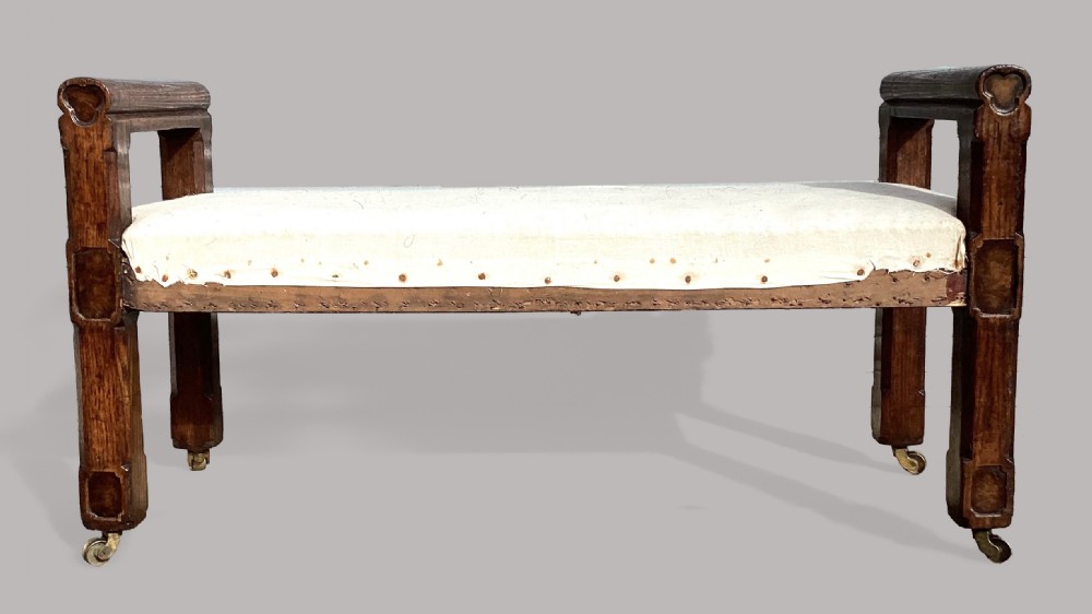 A mid-19th-century Reformed Gothic hall bench constructed from oak with burr elm inlays, featuring a padded white seat and brass castors. View XII