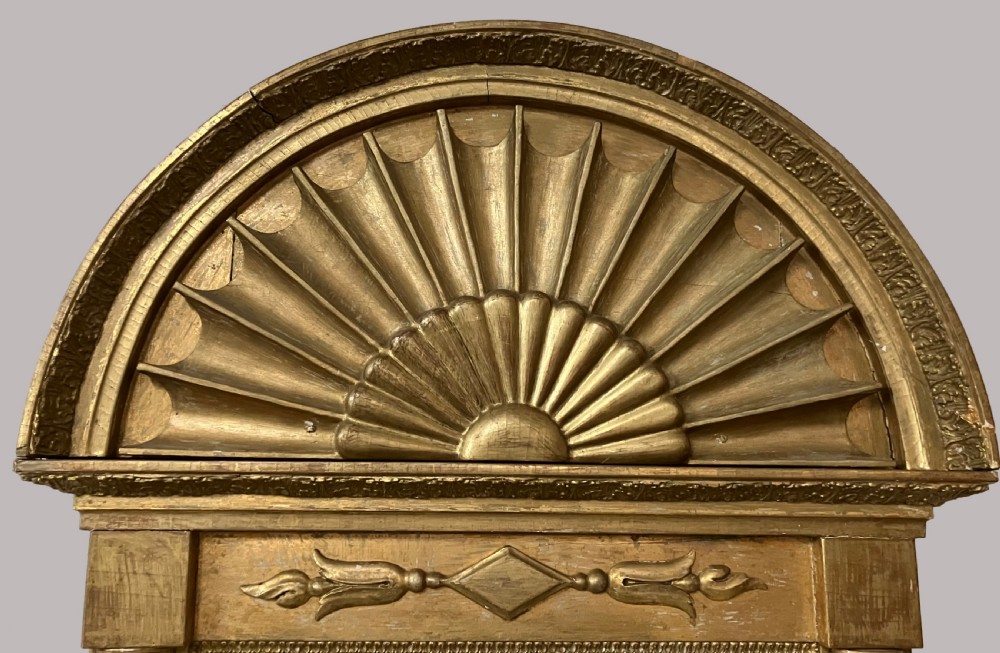 A nineteenth-century Swedish giltwood wall mirror featuring an arched lunette top with carved sunburst detailing and fluted side pilasters. View II