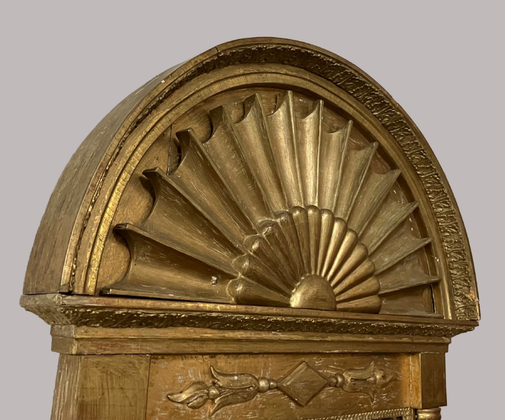 A nineteenth-century Swedish giltwood wall mirror featuring an arched lunette top with carved sunburst detailing and fluted side pilasters. View IV