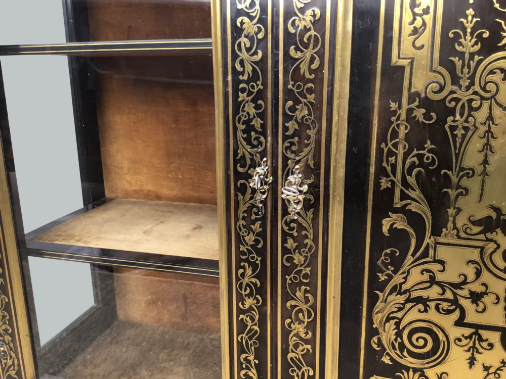 A 19th-century ebony breakfront side cabinet featuring central Boulle brass marquetry door panels flanked by two glazed display cabinet doors. View X