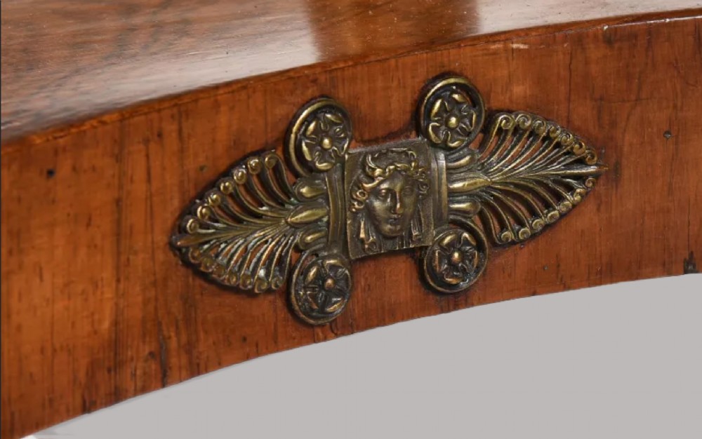 A Regency period rosewood drop-leaf sofa table featuring frieze drawers, turned columns, gilt brass mounts, and splayed legs with brass castors. View VIII