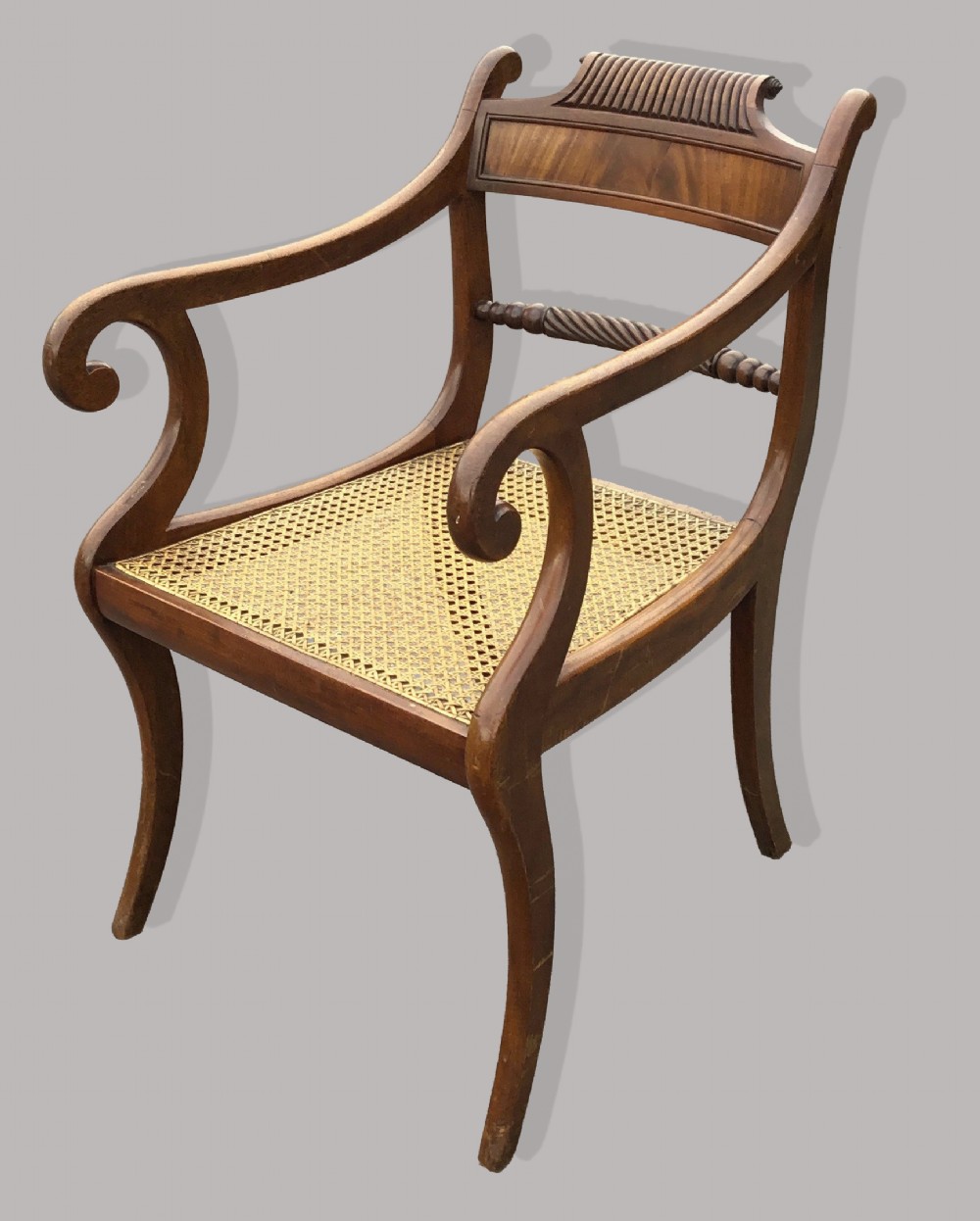 A set of six Regency mahogany open armchairs featuring woven cane seats, curved scroll arms, reeded top rails, and sabre legs. View IV