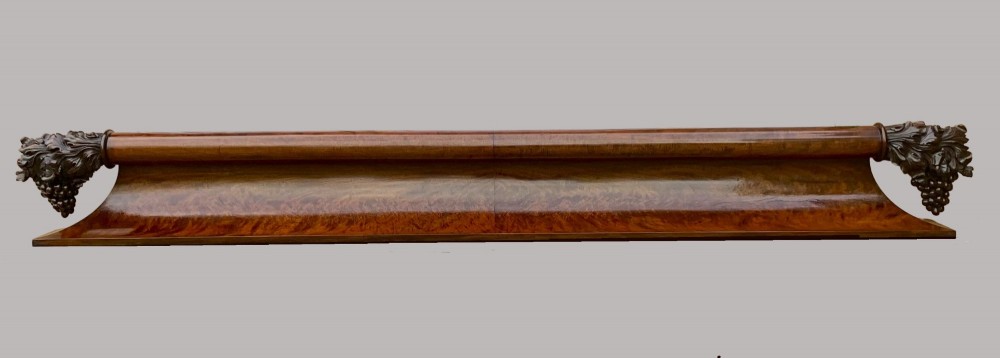 A long George IV figured mahogany pelmet featuring carved acanthus leaves and grape cluster finials at either end. View II