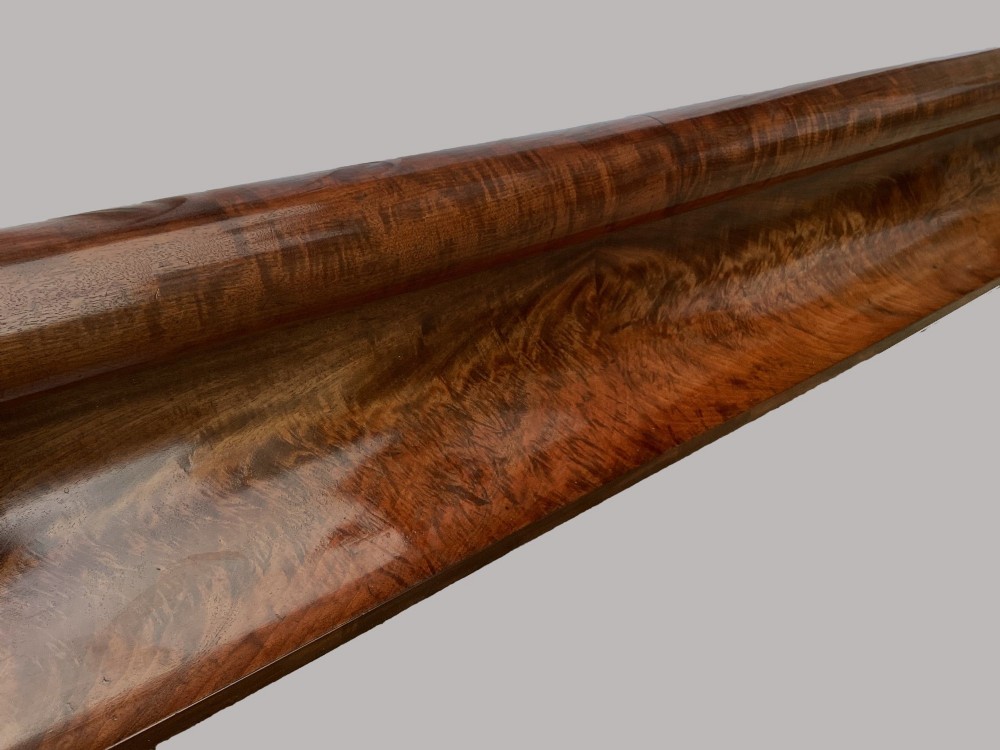 A long George IV figured mahogany pelmet featuring carved acanthus leaves and grape cluster finials at either end. View VI
