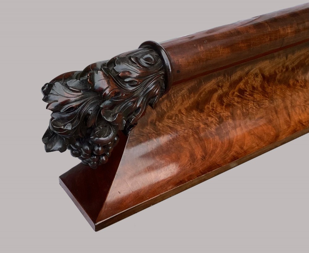 A long George IV figured mahogany pelmet featuring carved acanthus leaves and grape cluster finials at either end. View XI