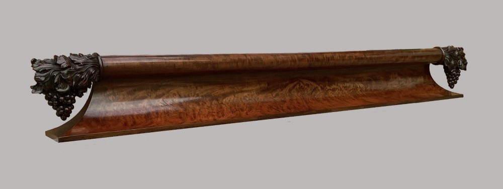 A long George IV figured mahogany pelmet featuring carved acanthus leaves and grape cluster finials at either end. View XII