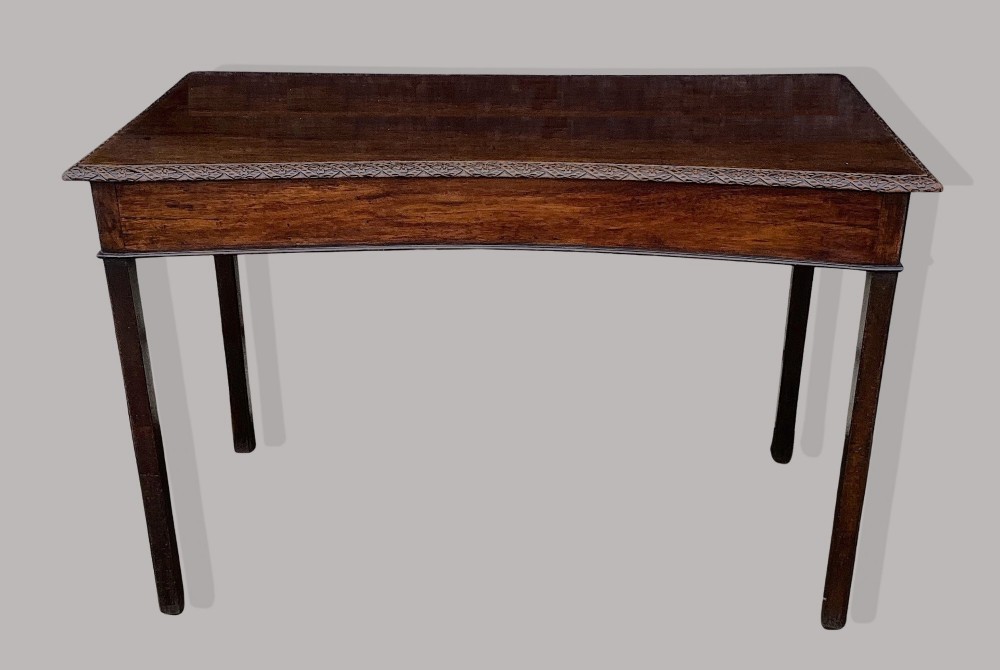 A George III mahogany side table featuring a rectangular carved-edge top, plain frieze, and straight legs.