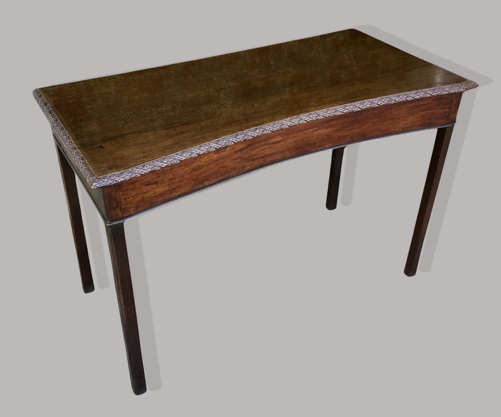 A George III mahogany side table featuring a rectangular carved-edge top, plain frieze, and straight legs. View II
