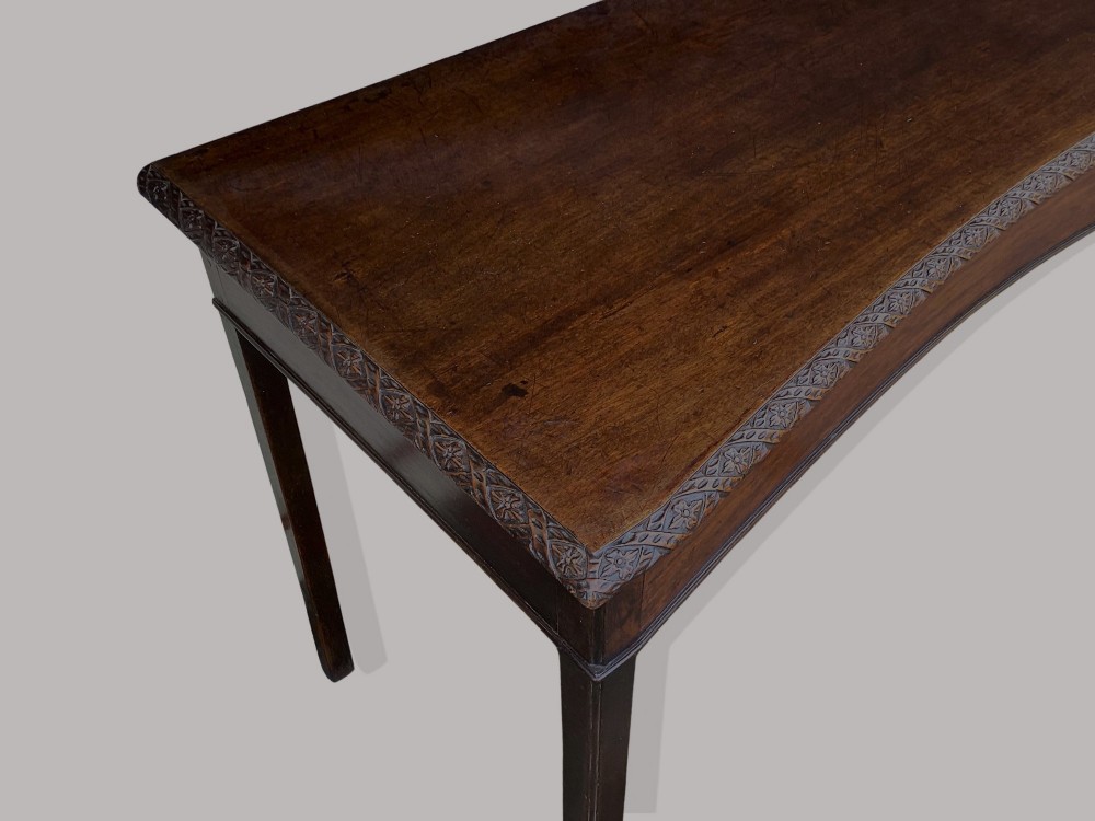 A George III mahogany side table featuring a rectangular carved-edge top, plain frieze, and straight legs. View IV