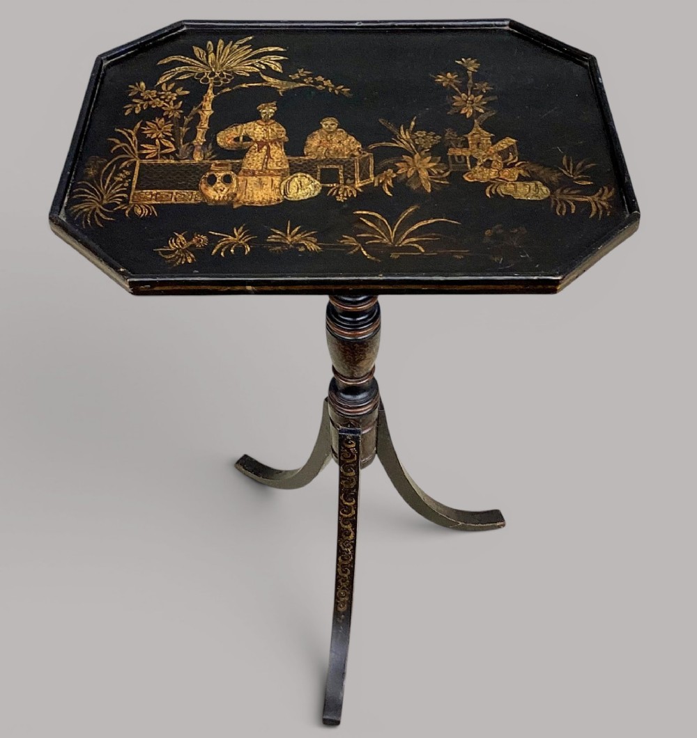 A Regency black lacquered octagonal top wine table with gilded Chinoiserie figure decoration on a turned tripod base.