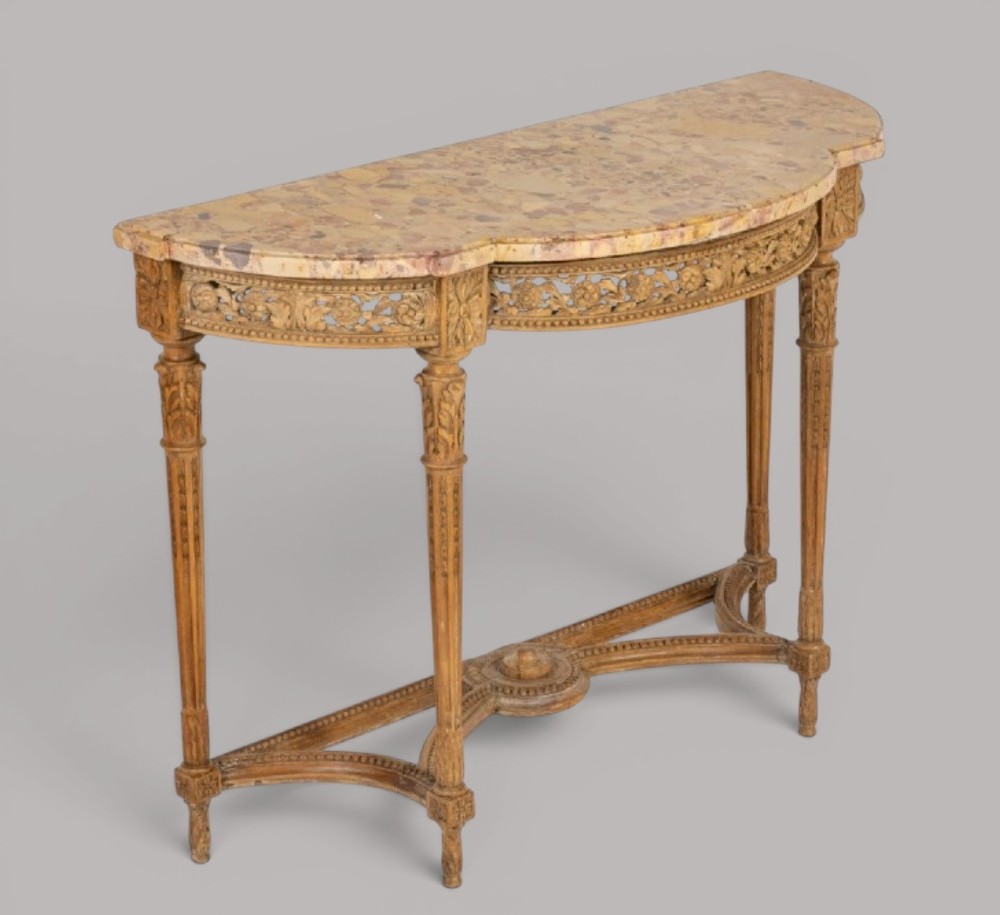 An 18th-century Louis XVI demilune console table featuring a variegated marble top, pierced carved floral frieze, fluted tapered legs, and a decorative central stretcher. View II