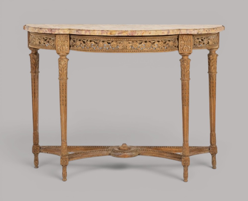 An 18th-century Louis XVI demilune console table featuring a variegated marble top, pierced carved floral frieze, fluted tapered legs, and a decorative central stretcher. View IV
