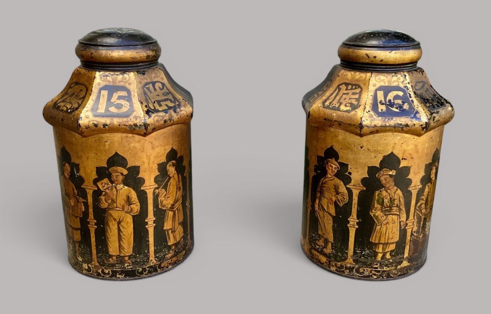 A pair of 19th-century black and gilt toleware tea canisters decorated with hand-painted Chinoiserie figures under arches and numbers fifteen and sixteen.