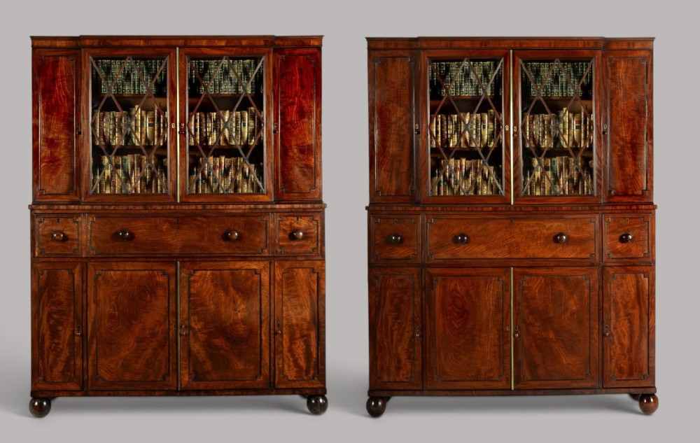 A pair of Regency mahogany library bookcases with diamond astragal glazed upper doors and panelled lower cupboard doors. View IX