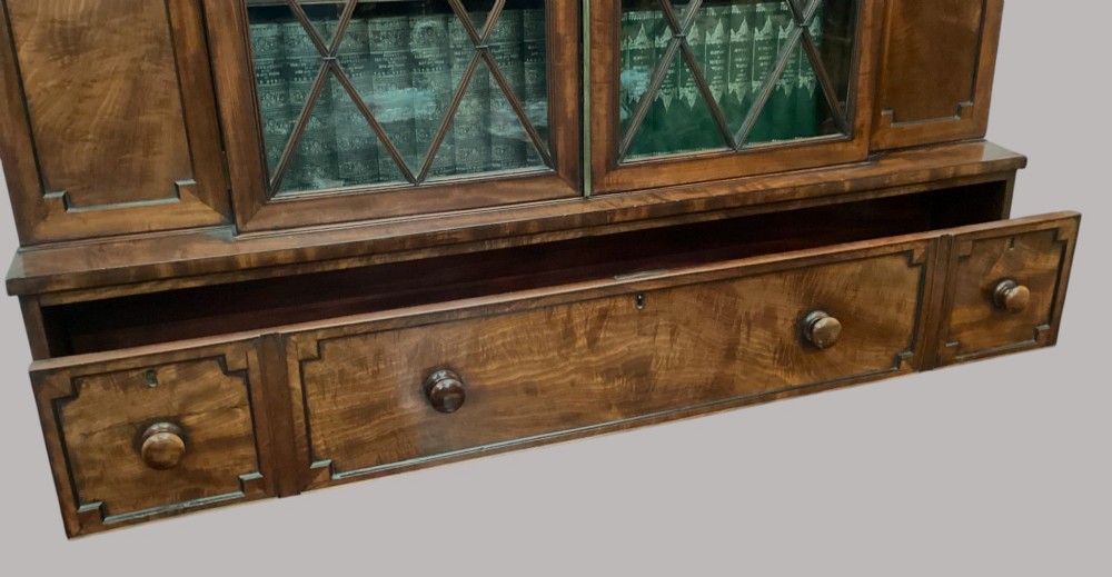 A pair of Regency mahogany library bookcases with diamond astragal glazed upper doors and panelled lower cupboard doors. View XII