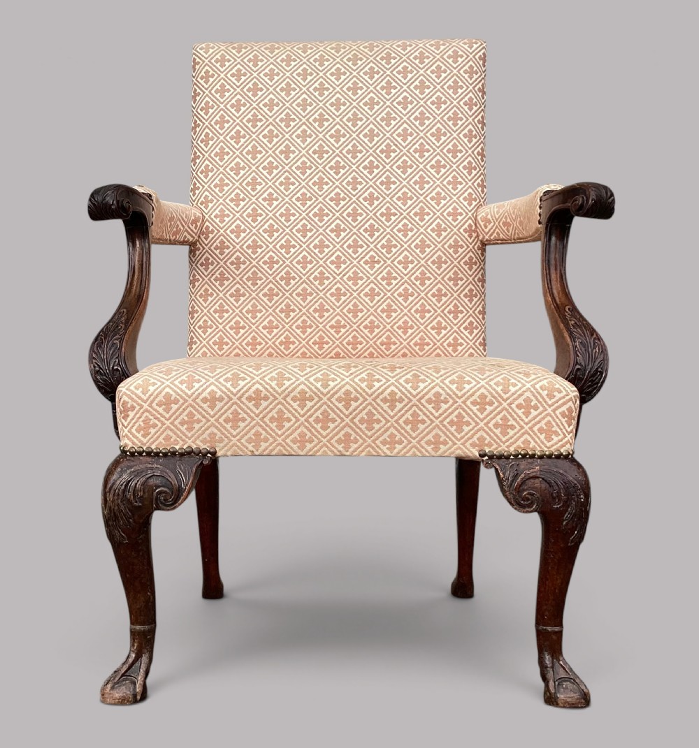 An 18th-century style George II mahogany open armchair upholstered in a cream and red geometric patterned fabric with carved cabriole legs. View VI