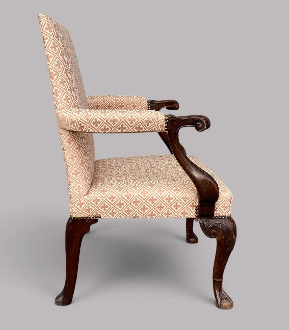 An 18th-century style George II mahogany open armchair upholstered in a cream and red geometric patterned fabric with carved cabriole legs. View VII