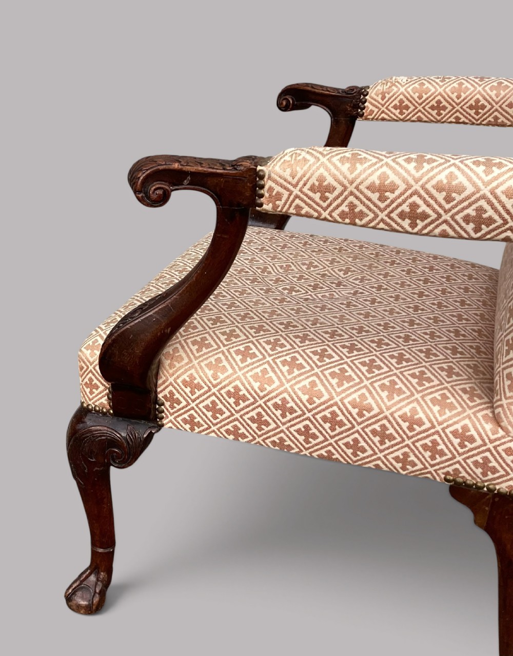 An 18th-century style George II mahogany open armchair upholstered in a cream and red geometric patterned fabric with carved cabriole legs. View IX