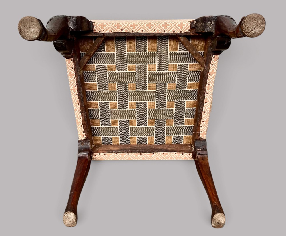 An 18th-century style George II mahogany open armchair upholstered in a cream and red geometric patterned fabric with carved cabriole legs. View X