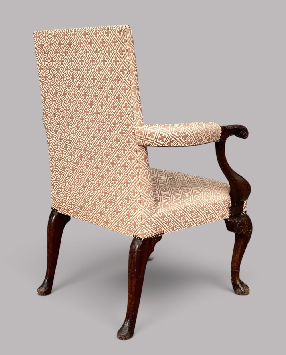 An 18th-century style George II mahogany open armchair upholstered in a cream and red geometric patterned fabric with carved cabriole legs. View XVII