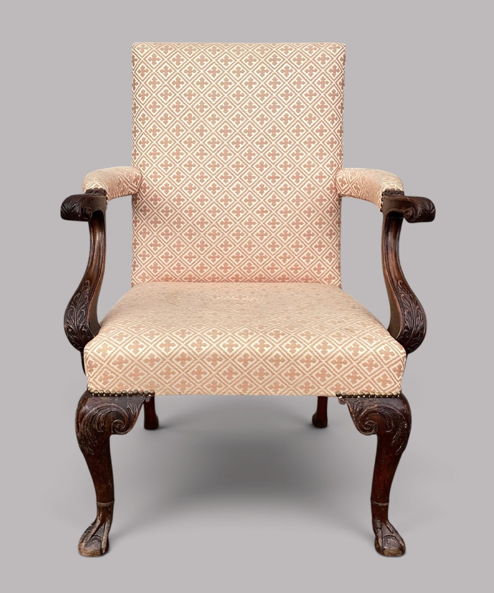 An 18th-century style George II mahogany open armchair upholstered in a cream and red geometric patterned fabric with carved cabriole legs. View XVIII