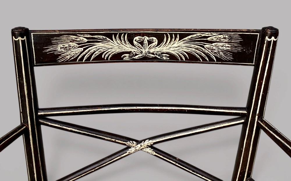 A Regency dark-painted wooden elbow chair featuring hand-painted white line decoration, an X-back splat, and a woven rush seat. View III